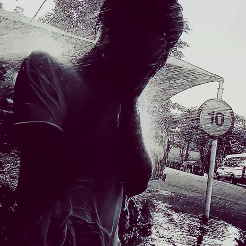 Purple-tinted image of a silhouetted person with their hands over their face being pelted with rain